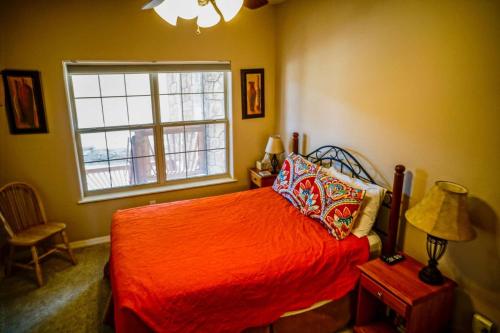 1 dormitorio con cama roja y ventana en Indian Point Penthouse 3BDR Condo, en Branson