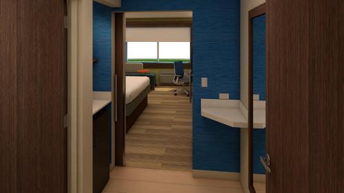 a room with a bedroom with a bed and a desk at Holiday Inn Express Atmore by IHG in Atmore