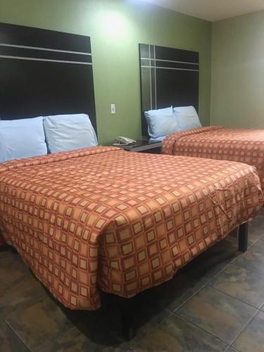 two beds in a hotel room with two bedsskirts at RED CROWN INN in Dallas
