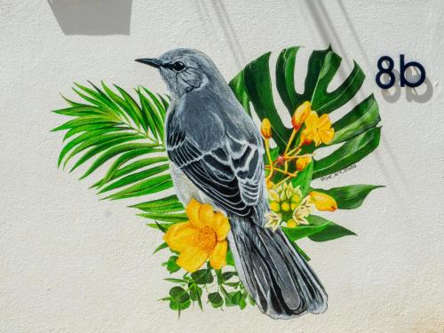 a bird is sitting on a painting of flowers at Deluxe Boutique Apartments Sonrisa - Adults only in Kralendijk