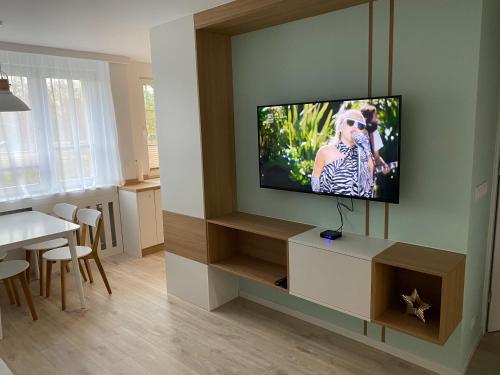 a living room with a flat screen tv on a wall at Apartament uTymka in Słupsk