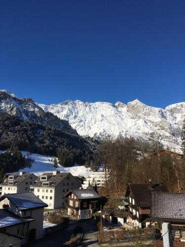 a town with snow covered mountains in the background at Nice Apartment private host Engelberg in Engelberg