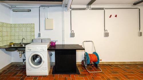 a laundry room with a washing machine and a table at Luxueuse et spacieuse villa avec sauna et piscine in Malmedy
