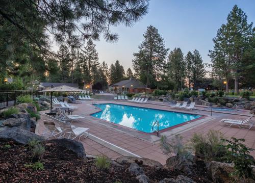 a swimming pool with lounge chairs and a resort at Seventh Mountain Resort in Bend