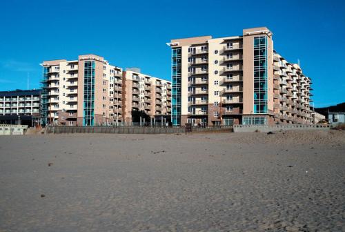 two tall buildings on the beach with a sandy beach at WorldMark Seaside in Seaside