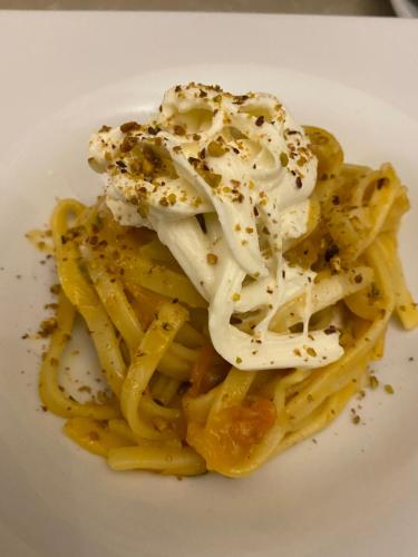 a white plate of pasta with sauce and cheese at Agriturismo Fiori d'Arancio in Palagiano