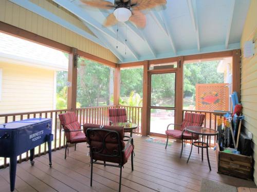 a porch with chairs and a table and a ceiling fan at E Huron 401 in Folly Beach