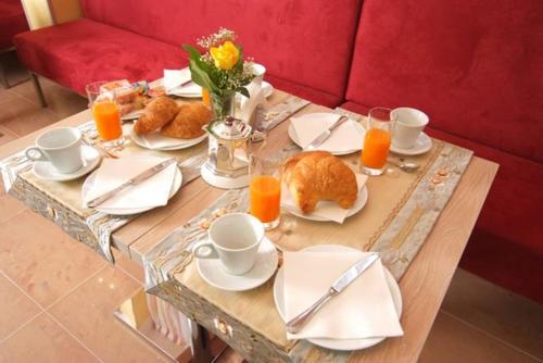a wooden table with food and orange juice on it at Hotel Cristal Eboli in Eboli