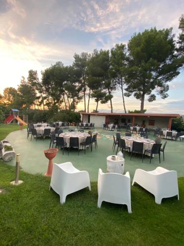 a restaurant with white tables and chairs on the grass at Agriturismo Fiori d'Arancio in Palagiano
