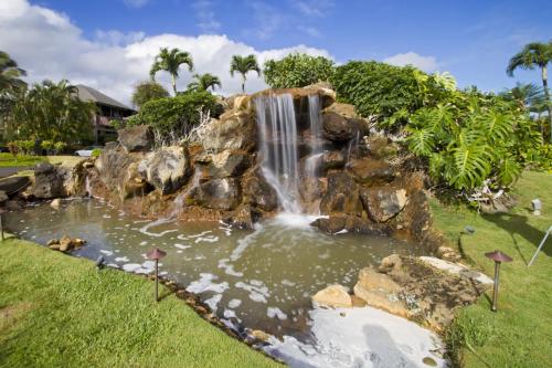 a waterfall in a park with a pond at Club Wyndham Ka Eo Kai in Princeville