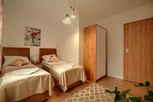 a room with two beds and a door in it at Dom w Milówce - Apartamenty na Kowolu in Milówka