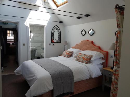 ein Schlafzimmer mit einem großen Bett mit weißer Bettwäsche und Kissen in der Unterkunft Gilbey's Bar, Restaurant & Townhouse in Windsor