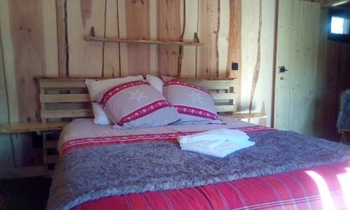 a bed with pink and white pillows in a room at Auberge De La Grange spa & sauna in Plainfaing