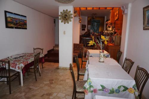 a dining room with two tables and chairs at Hostal Camiluz in Nazca