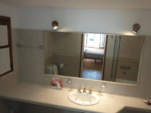 a bathroom with a sink and a large mirror at Casa Valeria del Mar 8 pax in Valeria del Mar