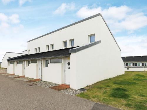 a white building with a black roof at 6 person holiday home in Brovst in Brovst