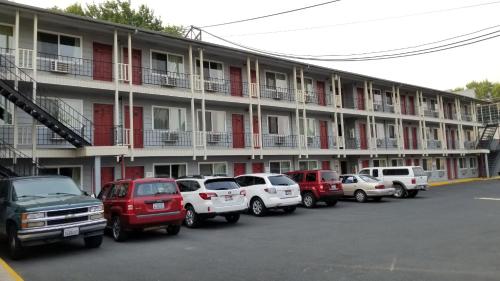 eine Reihe von Autos, die vor einem Gebäude geparkt sind in der Unterkunft Cougar Land Motel in Pullman