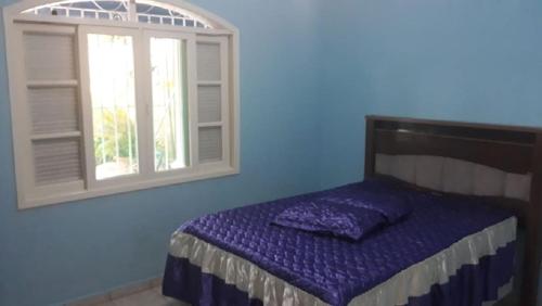 1 dormitorio con cama y ventana en CASA PRAIA PERUÍBE PISCINA, en Peruíbe