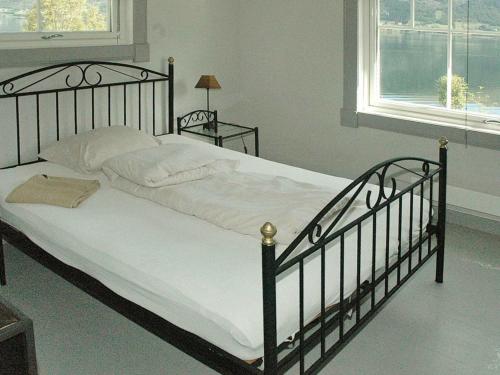 a bedroom with a large bed with white sheets at 11 person holiday home in Syvde in Myklebost