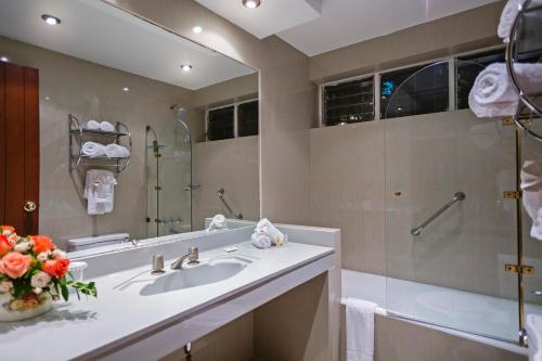 a bathroom with a sink and a large mirror at Club Hotel Centro de Convenciones Cusco in Cusco