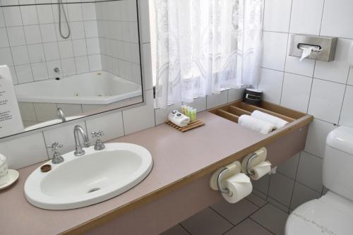 a bathroom with a sink, toilet and bathtub at The Black Bull Motel in Traralgon