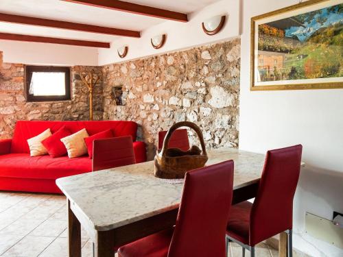 クロネにあるBelvilla by OYO Fienile Regoli Quattroのリビングルーム(赤いソファ、テーブル付)