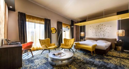 a hotel room with a bed and chairs and a table at Best Western Aquakub in Aix-les-Bains