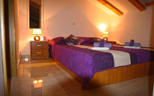 a bedroom with a large bed with purple sheets at Ballerina Apartment in Dubrovnik