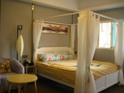 1 dormitorio con cama con dosel y mesa en Jiji Wu Homestay, en Jiji