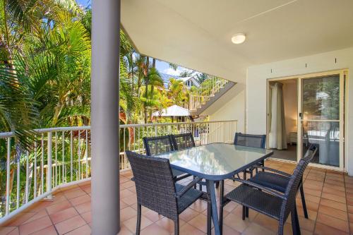 a patio with a table and chairs on a balcony at Mariner Bay Apartments in Byron Bay
