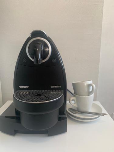 a black coffee maker and a cup on a table at Swiss Hotel Krummen Eich Pratteln Free Parking in Pratteln