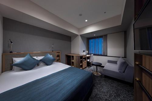 a hotel room with a bed and a chair at Hotel Villa Fontaine Grand Tokyo-Shiodome in Tokyo