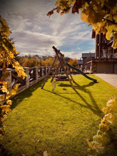 a swing set on the grass in a park at Chalet Rebeca 6 beds Donovaly in Donovaly