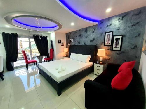 a bedroom with a bed and a couch and a table at Kandi Palace in Angeles