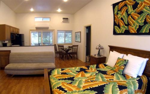 a bedroom with a bed and a living room at Keaau Place in Keaau