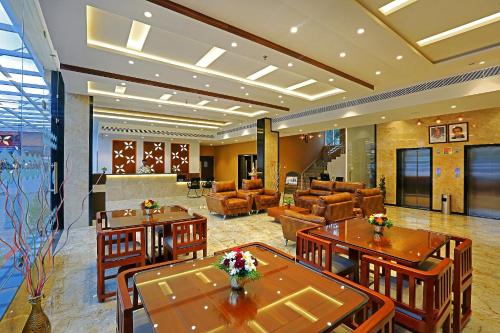 a hotel room with tables and chairs and a lobby at Renai Sreekrishna in Guruvāyūr