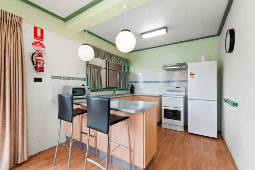 a kitchen with a counter and a refrigerator at Emmanuel Holiday Apartment in Lakes Entrance