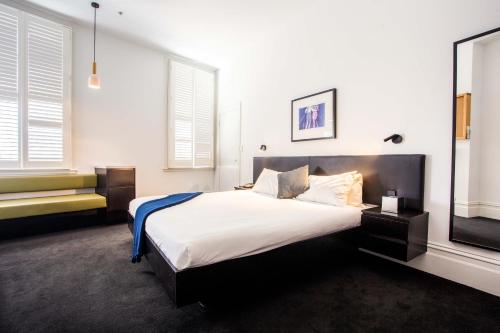 Middle Park Hotel في ملبورن: غرفة نوم بسرير كبير وتلفزيون