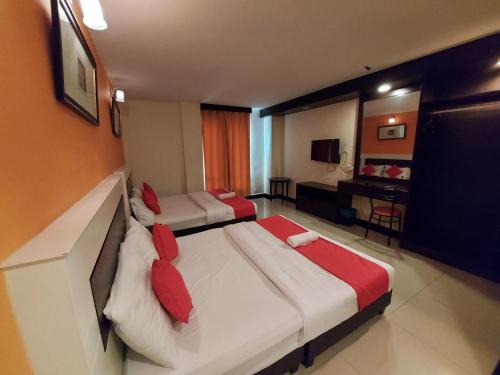a hotel room with two beds with red pillows at HOTEL SAHARA SDN BHD in Rawang