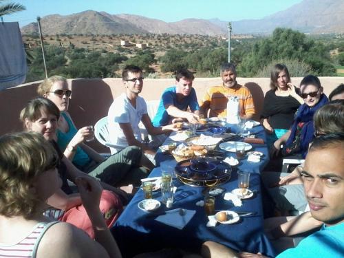a group of people sitting around a table with food at Auberge Gitelkst in Tafraoute
