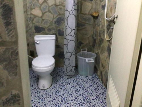 a bathroom with a toilet and a trash can at Phu Plai Fah in Chiang Rai