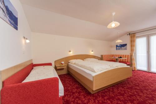 a bedroom with two beds and a red carpet at Kedul Lodge in Santa Cristina in Val Gardena