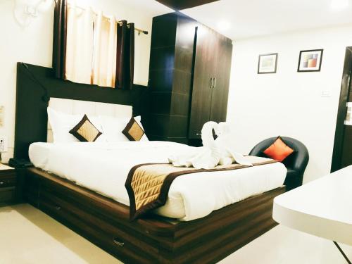 a bedroom with a large bed with a stuffed animal on it at Citi Inn in Patna