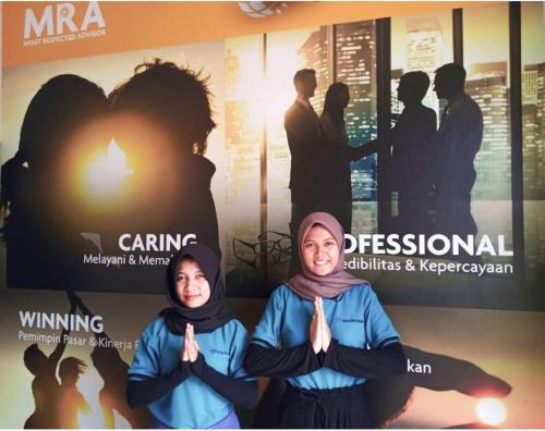 a couple of people praying in front of a poster at GRAND KHALIFAH Guesthouse in Sumbawa Besar