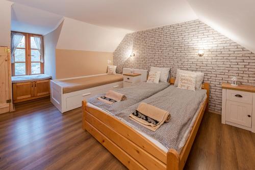 a bedroom with a large bed and a brick wall at HepeHuta Házikó in Háromhuta