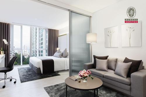 una camera d'albergo con letto e divano di Somerset Maison Asoke a Bangkok
