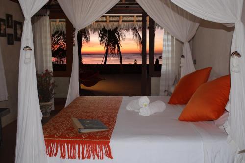 1 dormitorio con 1 cama y vistas a la playa en T-Land Resort, en Nembrala