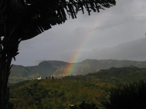 a rainbow in the sky over a green valley at Aire Libre Descanso in San Francisco