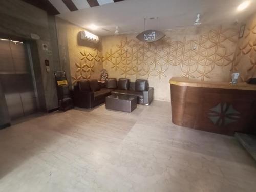 a lobby with a couch and a bar in a room at La Riviera Suites in Hyderabad