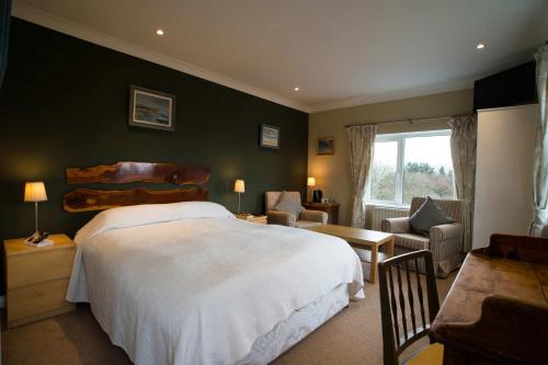 a bedroom with a large bed and a living room at Sharamore House B&B in Clifden